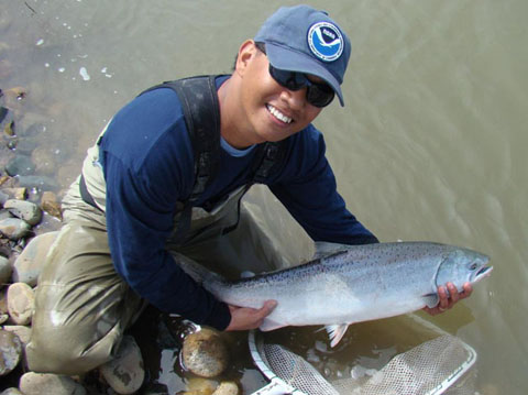 A NOAA biologist with a chinook salmon.: Photograph courtesy of NOAA